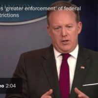A person in a suit and tie stands at a podium with an American flag in the background. The text overlay reads, "Spicer foresees 'greater enforcement' of federal regulations on cannabis." There is a play button indicating a video with a duration of 2:04. CA Norml
