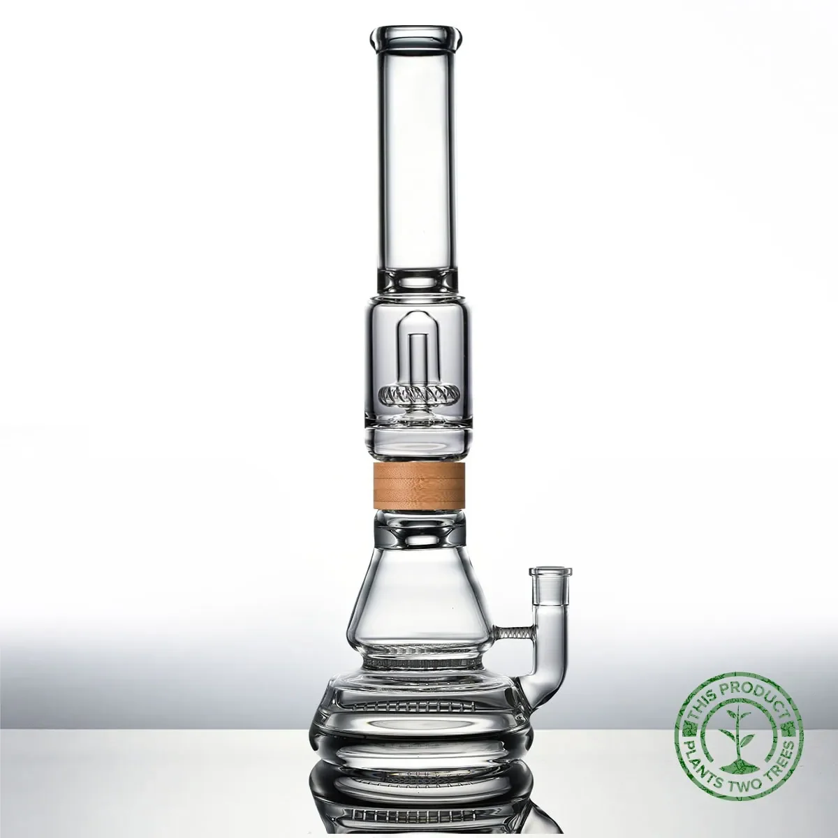 A clear glass water bong with a beaker base, straight neck, and a wooden accent around the middle, shown on a reflective surface. A green "Plants Two Trees" seal is in the bottom right corner. Ca NORML